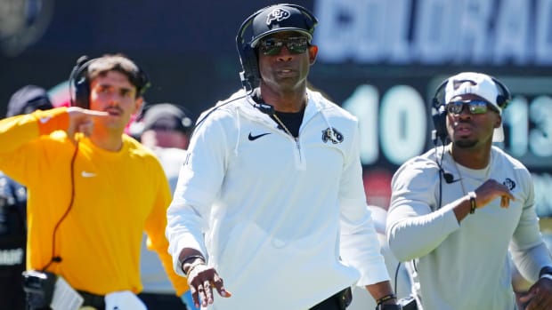 Colorado coach Deion Sanders walks on the sideline during a game.